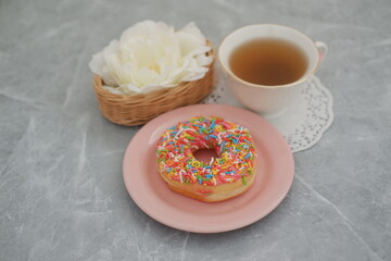donut and cup of tea on the marble table