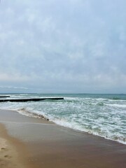 cloudy grey seascape, waved sea horizon, windy at the sea, empty beach