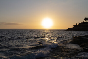 A breathtaking sunset over the ocean, with golden hues reflecting off the waves. This tranquil scene captures the beauty of the beach at dusk, perfect for themes of relaxation and nature’s beauty.