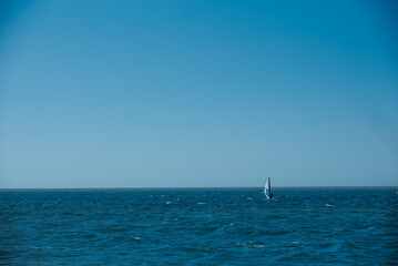 Fototapeta premium A sailboat is floating in the ocean on a clear day