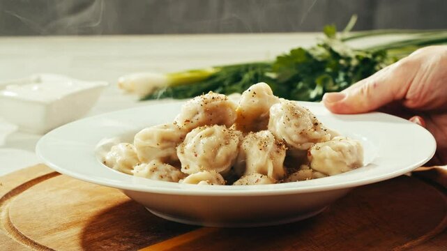 Dumplings in cafe, close up, Eating and serving Meat frozen dumplings in restaurant with mayo sour cream sauce, Ukranian, polish, Russian traditional pelmeni cooking process, vareniki ravioli pierogi