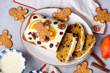 Pumpkin Christmas cake with dried fruits, spices and cheese frosting on a Christmas rustic background