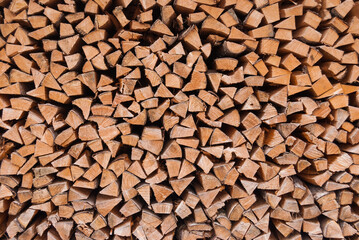 Chopped wood piled in a woodpile and prepared for heating in winter. Alpine Switzerland