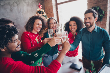 Photo of attractive young people employees drinking champagne new year decoration interior...