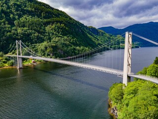 Obraz premium Aerial view of suspension bridge over scenic fjord.