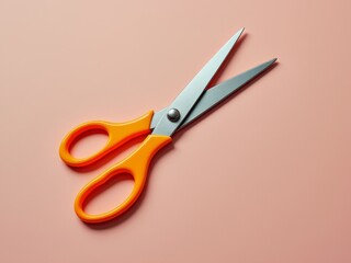 Bright orange-handled scissors with stainless steel blades on a pastel pink background in close-up view