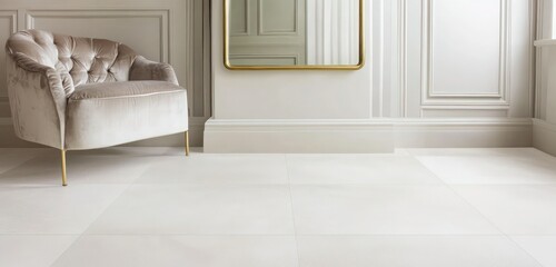 A sleek white stone floor with soft beige tones, complemented by a plush velvet armchair and brass-framed mirror.