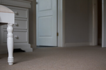 Close up of a stool leg in beige bedroom from floor level