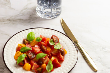 Salad with halves of red and yellow tomatoes cherry with basil