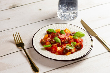 Salad with halves of red and yellow tomatoes cherry with basil