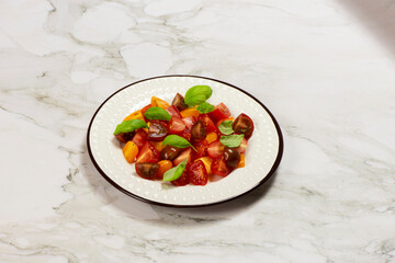 Salad with halves of red and yellow tomatoes cherry with basil