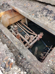 Repair of emergency rusty sewer pipes and faucets in an open alcove under the road on the street in...
