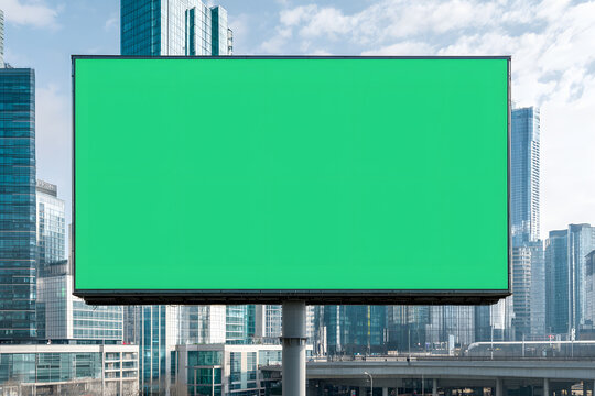 A large green screen billboard mounted on a building, ready for customisable digital content, standing out against the urban landscape.