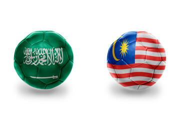 football balls with national flags of malaysia and saudi arabia ,soccer teams. on the white background.