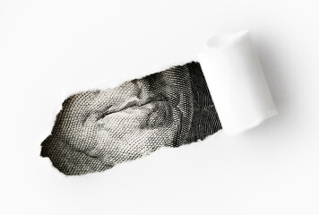 A torn piece of a U.S. one-hundred-dollar bill, focusing on a close-up of Benjamin Franklin’s mouth and chin. Concept of financial disruption, economy, and the fragility of money, physical currency.