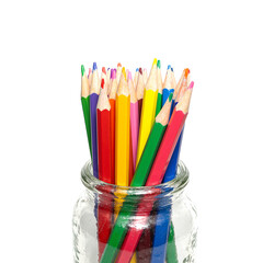 Vibrant rainbow pencils in clear glass jar on white background