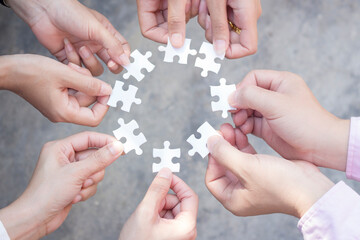 teamwork of business people assembling jigsaw puzzle