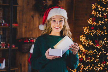 Photo of cheerful teen girl amazed open gift box dressed green christmas garment tradition atmosphere decor vibe house indoors room