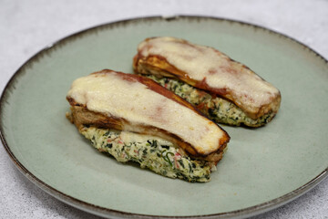Healthy eating. Closeup view of stuffed zucchinis with ricotta, kani kama, spinach and gratin cheese	
