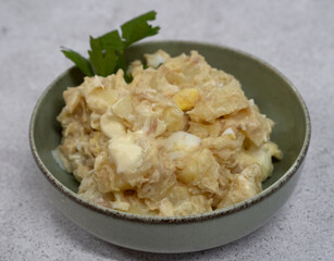 Potato salad. Closeup view of a salad made with tuna, sliced boiled potatoes, a hard boiled chopped egg and mayonnaise in a bowl
