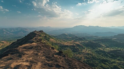 Obraz premium A panoramic view of a mountain range with a blue sky and white clouds.
