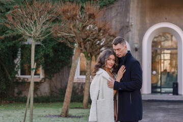 Fototapeta premium a joyful couple walking through a charming European city in winter. Wedding, love, street style