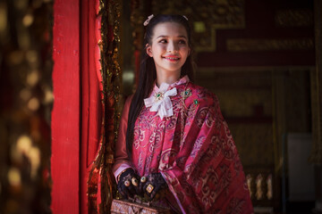 Beautiful Asian woman tourist wearing traditional Thai dress costume. The travel destination is Wat San Payang Luang Temple famous place of tourist attraction in Lamphun, Thailand. Portrait fashion.