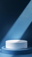 Fototapeta premium Minimalist product display featuring a white cylindrical podium on a blue circular base, illuminated by a dramatic diagonal beam of light.