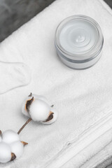 White terry towel next to the cream. Body towel.