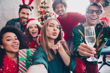 Portrait of group friends colleagues take selfie send air kiss hold champagne christmas party loft...