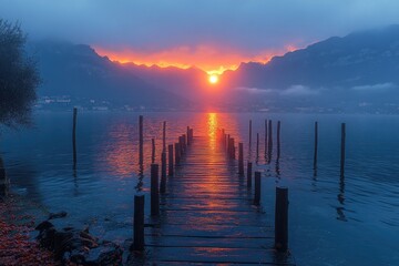 Fototapeta premium A wooden dock extends into a lake at sunset. This image is perfect for illustrating concepts like hope, dreams, or a journey towards a new beginning.