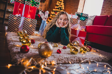 Full body photo of teen girl lying floor gifts wear green christmas clothes enjoy modern cozy x-mas party decoration interior flat indoors
