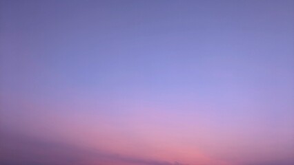 A serene twilight sky, painted with soft hues of purple and pink. The sky is clear and vast, with a...