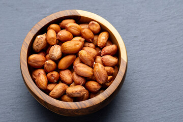 Roasted Peanuts in Wooden Bowl on Gray Background