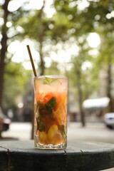 Glass of tasty refreshing drink and straw on table