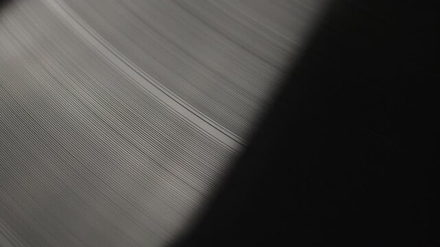 Retro Vinyl record player playing music, close-up macro shot of vintage LP disc old phonograph spinning. Retro music player at home.