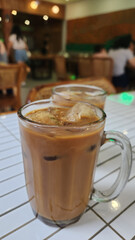 Traditional malay coffee served with sweetened condensed milk and evaporated milk in a glass on a table in a coffee shop