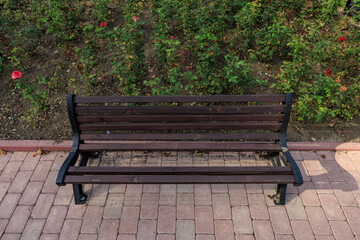 A wooden bench sits on a brick walkway, broken element