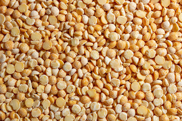 Uncooked Polished Split Peas Background. A Culinary Canvas of Dry Yellow Peas, Creating a Lively and Textured Background for Gourmet Cooking. Scattered Raw Polished Peas. Healthy Eating Ingredients
