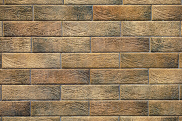 A brick wall with brown and tan bricks