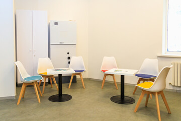 Modern meeting room with colorful chairs and tables arranged for discussion