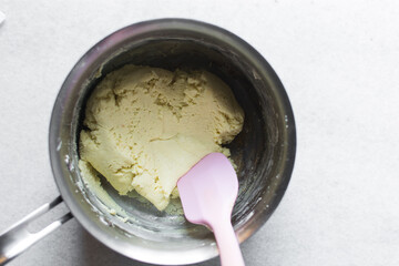 Overhead view of tuwon madara dough in a silver saucepan, nigerian alawar madara milk candy,...