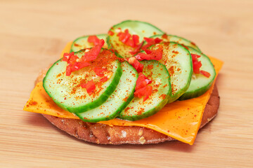 Crispy Cracker Sandwich with Fresh Cucumber, Cheese and Paprika on Cutting Board. Diet Food. Easy Breakfast. Quick and Healthy Sandwiches. Crispbread with Tasty Filling. Healthy Dietary Snack