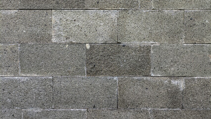 Stacked natural stone wall. Stone cladding wall made of natural gray stone slabs stacked in rows. Panels for exterior. Decorative slate wall surface pattern.