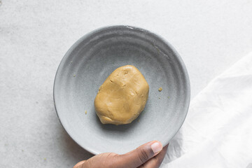 top view of mooncake dough, Overhead view of homemade mooncake dough in a grey bowl, process of making mooncakes for Lunar New Year and mid-autumn festival