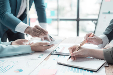 Businessmen discuss charts and graphs showing successful teamwork. Close-up of a team of Business Colleagues analyzing financial data at a table in the office.