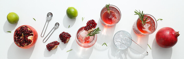 Red cocktail with fresh pomegranate and lime on a white background