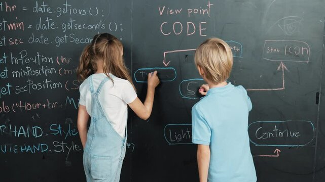 Caucasian girl writing blackboard with engineering prompt or coding, programing system written in STEM technology classroom and turnaround to looking at camera while boy showing thumb. Erudition.