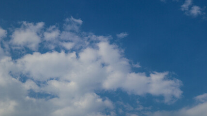 Obraz premium A vibrant blue sky with fluffy white clouds, partially obscured by a blurred rectangular overlay. Perfect for backgrounds, nature themes, or weather-related projects.