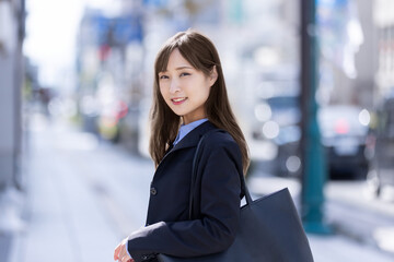 振り返って微笑むスーツの女性　Business
